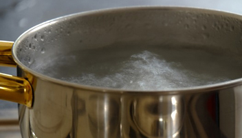 water boils out of a saucepan with jellied meat